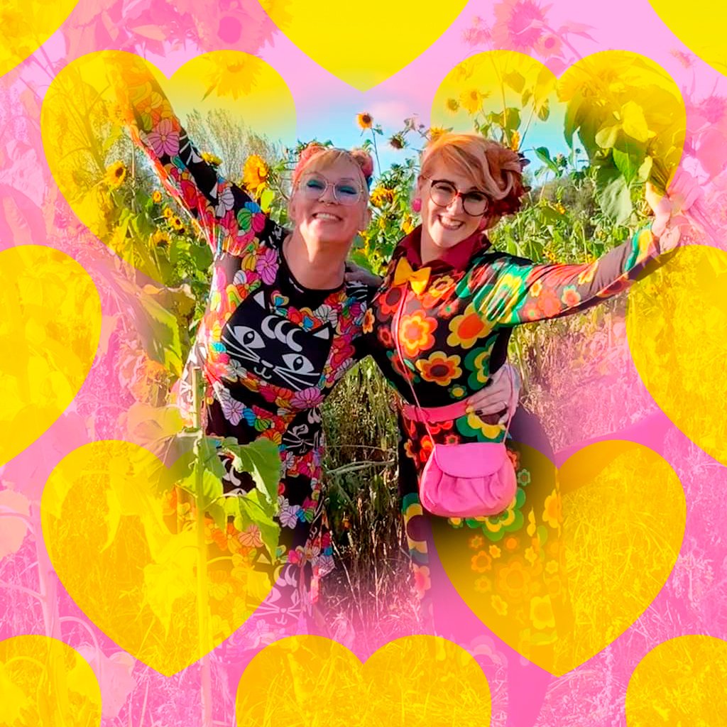 Two smiling women in colorful dresses by SHALMIAK. Sunshine, sunflowers, hearts and happiness.